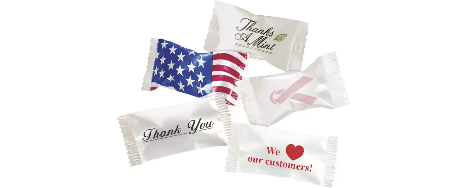A variety of individually wrapped buttermints featuring different professional and holiday wrapper designs