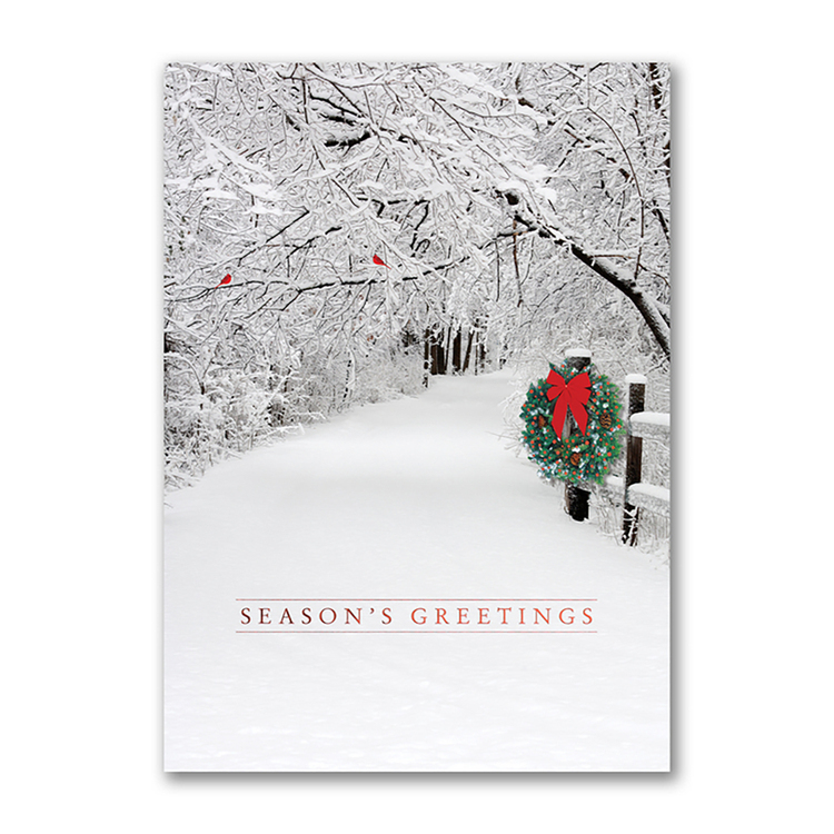 Season’s Greetings card featuring a snow-covered winter lane with a festive wreath and red cardinals