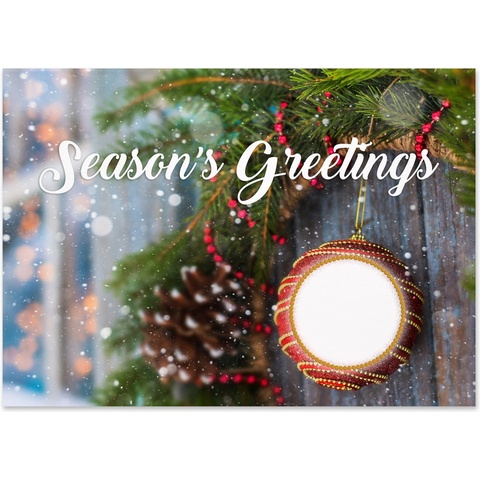 Season's Greetings holiday card featuring a festive ornament, evergreen branches, pinecone accents, and gentle snowfall