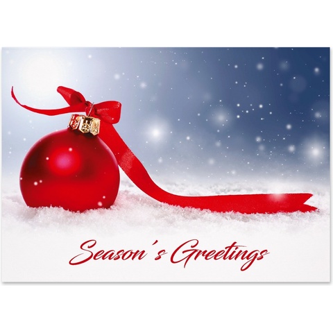 Season's Greetings holiday card featuring a red Christmas ornament with ribbon resting in fresh snow against a winter night backdrop