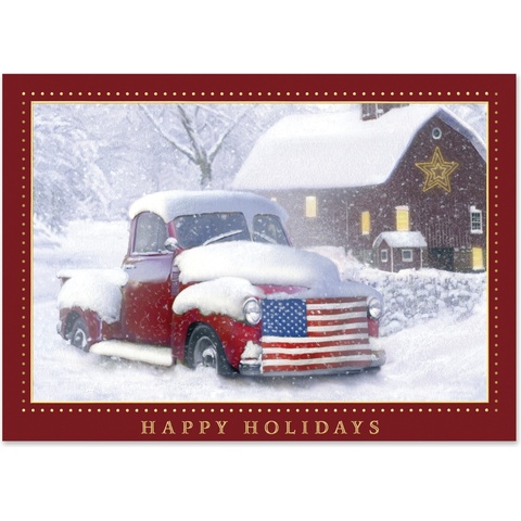 Holiday card featuring a snow-covered vintage red pickup truck with an American flag grille parked outside a rustic country barn in winter