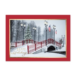 Holiday greeting card featuring a snow-covered red bridge, decorated Christmas tree, vintage lampposts, and a peaceful winter landscape